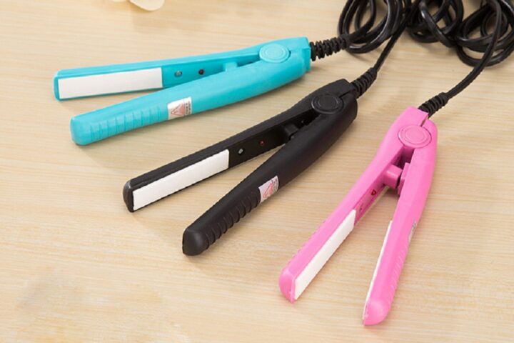 Một cô gái đang thực hiện cách sử dụng máy ép tóc mini để làm thẳng tóc tại nhà, thể hiện sự tiện lợi và đơn giản của thiết bị.