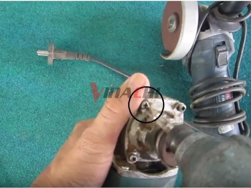 Sử dụng tua vít để tháo 4 chiếc ốc cố định ở đầu máy mài, là bước đầu tiên trong cách tháo nhông máy mài