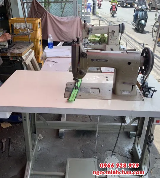 Người vận hành đang điều khiển vải khi may bằng máy may công nghiệp 1 kim, thể hiện cách sử dụng máy may công nghiệp 1 kim để tạo đường may thẳng