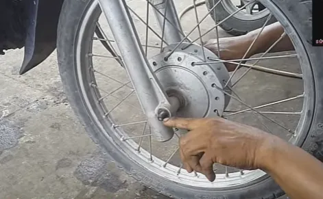 Tháo bu lông trục bánh trước xe máy Honda