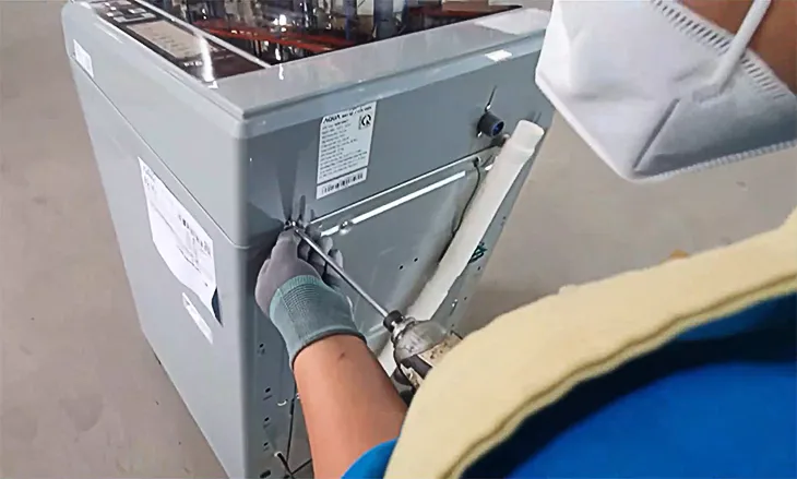 Tháo ốc vít cố định mặt máy giặt Panasonic trước khi tháo van cấp nước