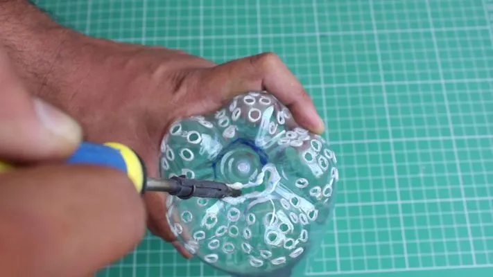 Khoét lỗ và đục các lỗ thông khí trên đáy chai làm vỏ máy hút bụi tự chế