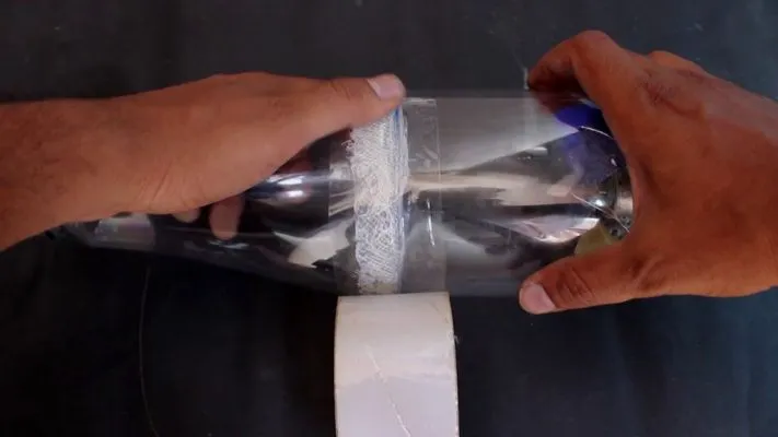 Cố định hai phần chai nhựa và màng lọc bụi lại với nhau cho máy hút bụi tự chế