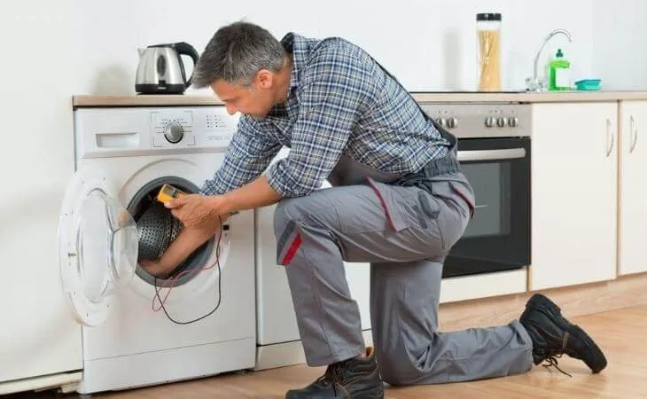 Người đang thực hiện các bước lắp đặt máy giặt