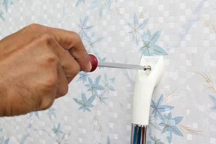 Sử dụng tua vít để siết chặt các ốc vít cố định vòi sen, đảm bảo chắc chắn