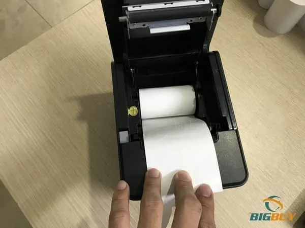 Đặt cuộn giấy in vào khe máy POS đúng chiều