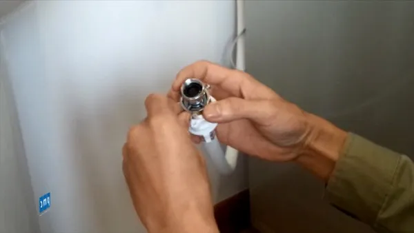 Kỹ thuật viên đang thực hiện lắp đặt vòi cấp nước cho máy giặt