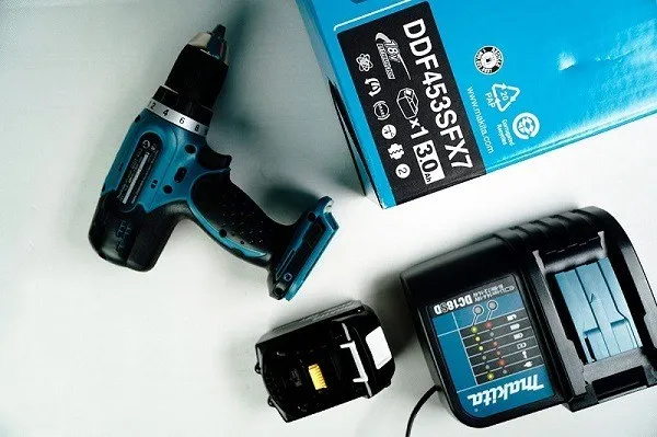 Hình ảnh một người đàn ông đang sạc pin máy khoan cầm tay