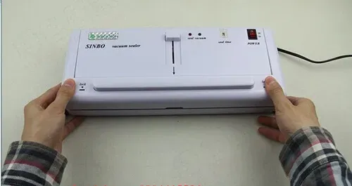 Mở nắp máy hút chân không DZ300A bằng nút khóa hai bên để chuẩn bị đóng gói.