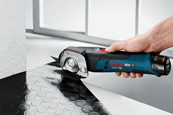 Người thợ đang thực hành sử dụng máy cắt cầm tay đúng cách để cắt kim loại trong xưởng cơ khí