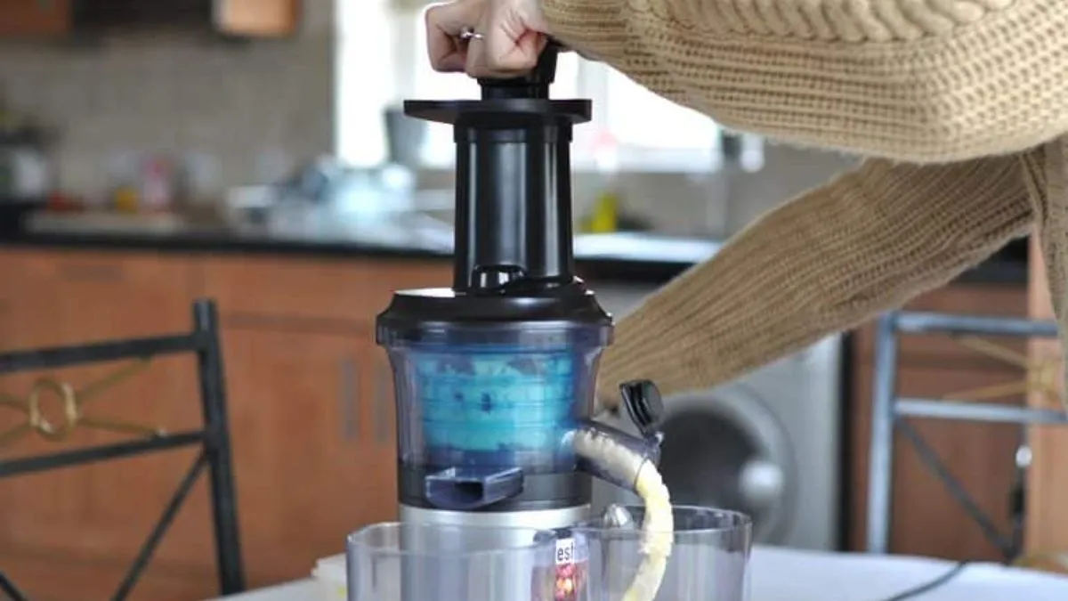 Người dùng đang thực hiện các bước sử dụng máy ép chậm Panasonic để tạo ra nước ép tươi ngon tại nhà.