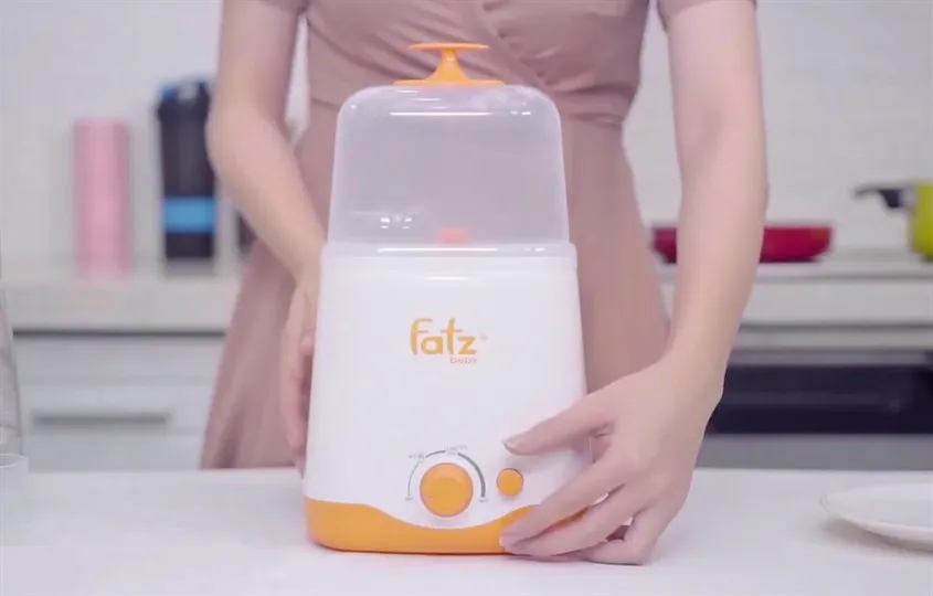 Sơ đồ nguyên lý hoạt động của máy hâm sữa Fatzbaby, mô tả cơ chế truyền nhiệt làm nóng sữa