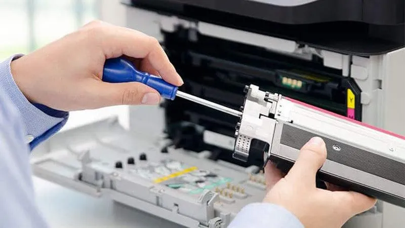 Một kỹ thuật viên đang kiểm tra và sửa chữa máy in Canon LBP 2900, nhấn mạnh tầm quan trọng của việc tìm kiếm dịch vụ chuyên nghiệp