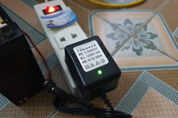 Ắc quy xe máy điện trẻ em đang được sạc đầy, cần rút sạc khi đầy pin