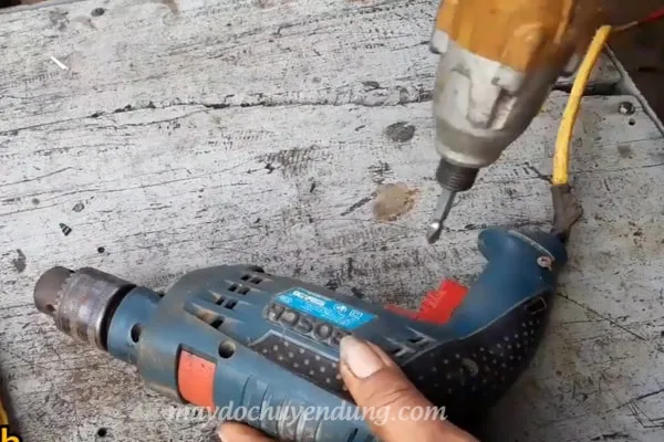 Sử dụng máy bắt vít để tháo vỏ máy khoan Bosch chuẩn bị cho quá trình sửa chữa