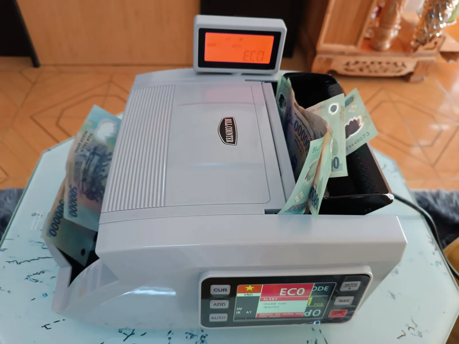 Một người thợ đang kiểm tra và làm sạch máy đếm tiền bị kẹt, giúp khôi phục hoạt động đếm tiền chính xác.