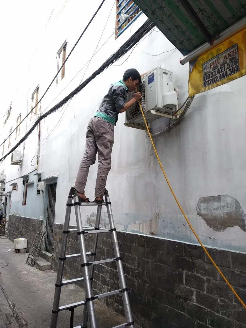 Kỹ thuật viên đang kiểm tra dàn nóng máy lạnh Inverter, một bước quan trọng trong quy trình allintitle:cách sửa máy lạnh inverter an toàn và hiệu quả.