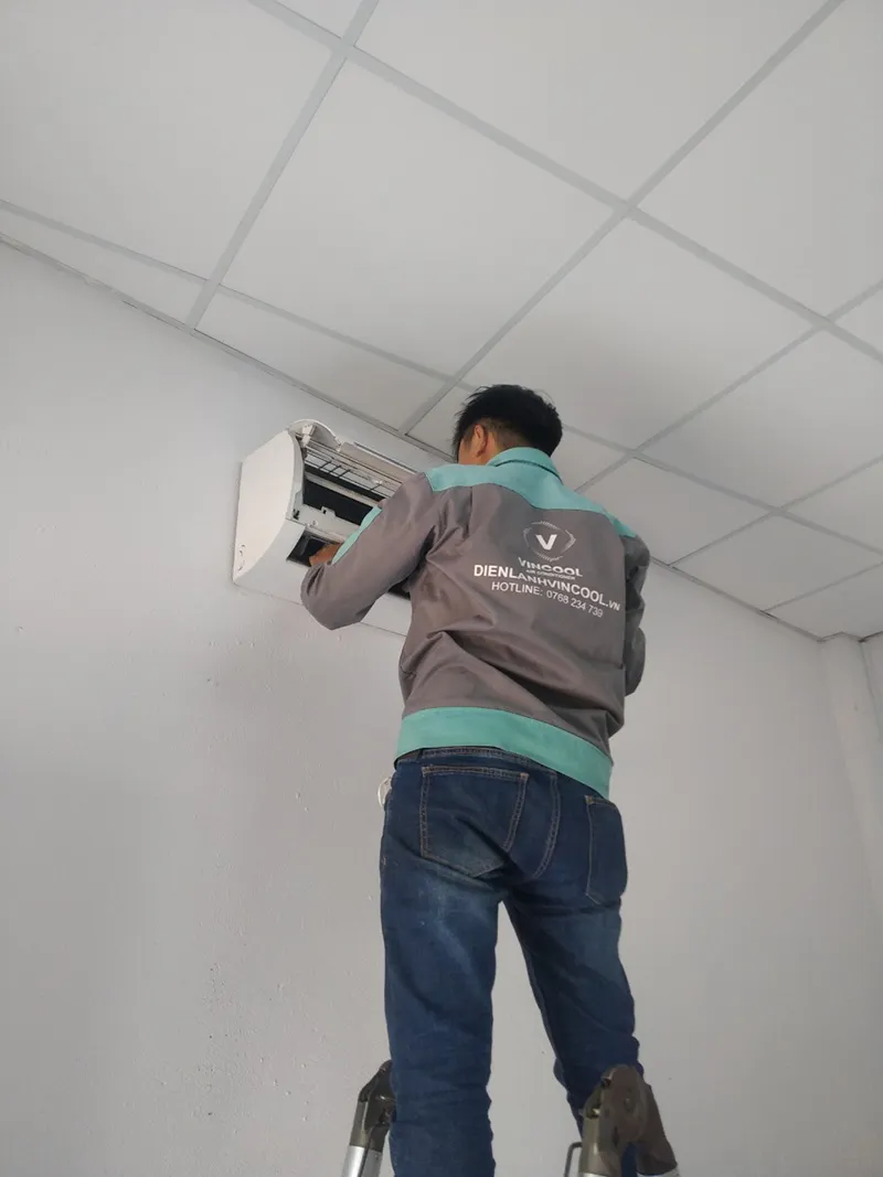 Thợ điện lạnh chuyên nghiệp đang thực hiện bảo dưỡng dàn lạnh Inverter, đảm bảo tuân thủ các nguyên tắc cách sửa máy lạnh inverter.