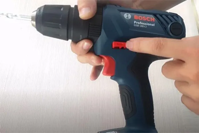 Hình ảnh một người thợ đang thao tác lắp mũi khoan vào đầu khoan tự động của máy khoan cầm tay