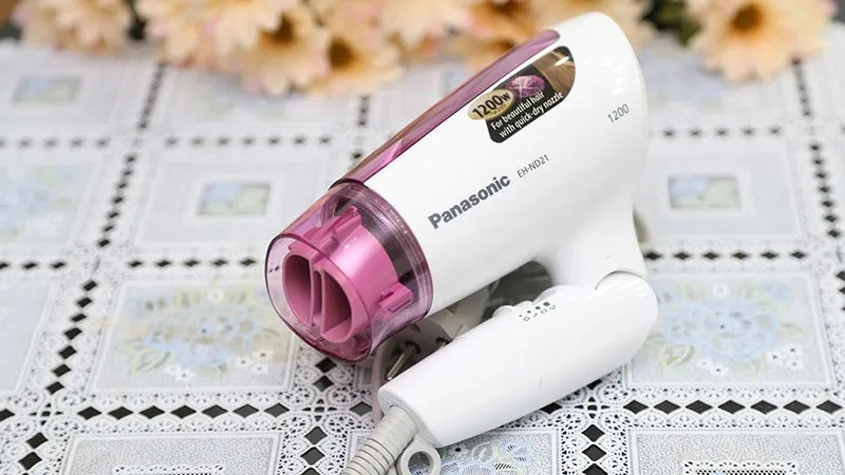 Người dùng đang tháo lưới lọc phía sau máy sấy tóc, bước đầu tiên trong cách tháo máy sấy tóc để kiểm tra và vệ sinh lưới lọc.