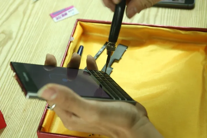 Tháo hai ốc vít dưới bàn phím để mở Blackberry Passport