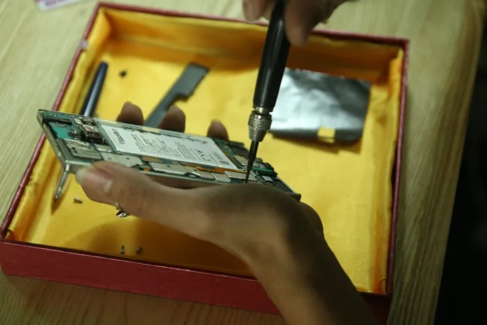 Tháo khoảng 8 con ốc nhỏ giữ mainboard của Blackberry Passport với khung máy