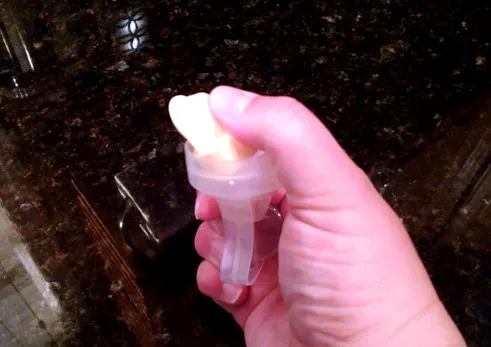 Van vàng đang được ấn để tách rời khỏi máy hút sữa Medela