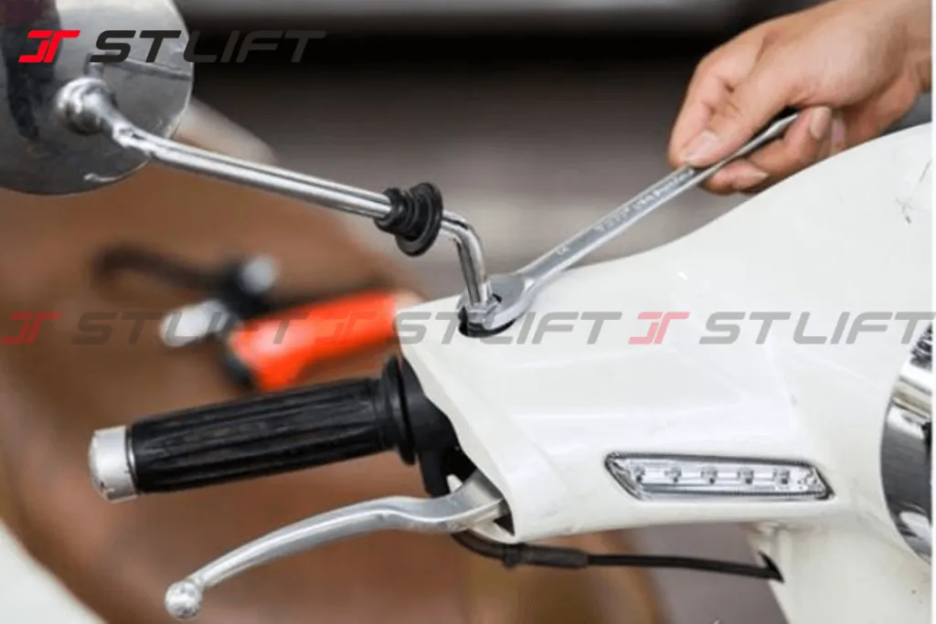 Người thợ đang thực hiện cách tháo mặt gương xe máy và lắp đặt gương chiếu hậu mới một cách tỉ mỉ, đảm bảo an toàn giao thông.