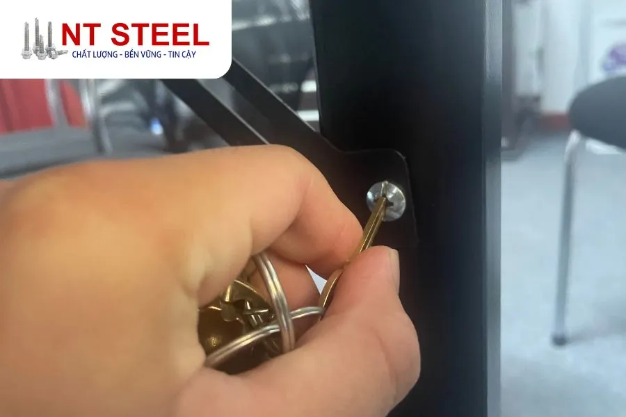 Cách vặn ốc nhỏ không cần tua vít bằng cạnh răng của chìa khóa