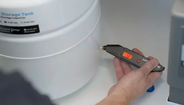 Cho đầu máy dò áp suất vào van khí để kiểm tra lượng áp suất và các kết nối ống trong bình áp máy lọc nước