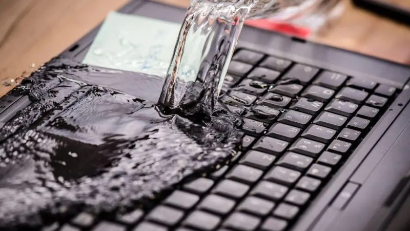 Hình ảnh một bàn phím máy tính bị dính chất lỏng, cảnh báo nguyên nhân phổ biến khiến bàn phím không hoạt động và cần cách sửa bàn phím máy tính không gõ được.