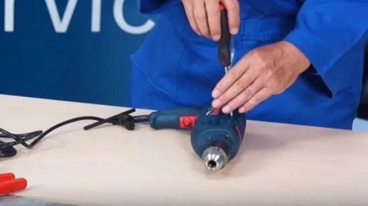 Dùng tua vít tháo vỏ máy khoan