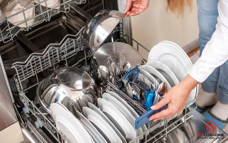 Xếp bát đĩa ra khỏi máy rửa bát sau khi kết thúc chu trình