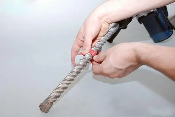 Kỹ thuật viên đang xác định độ sâu và đường kính lỗ khoan, một phần thiết yếu của cách khoan bê tông chuyên nghiệp.