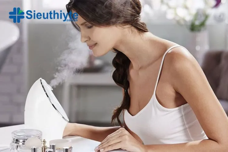 Người phụ nữ đang xông mặt bằng máy xông mini với hơi nước ấm áp