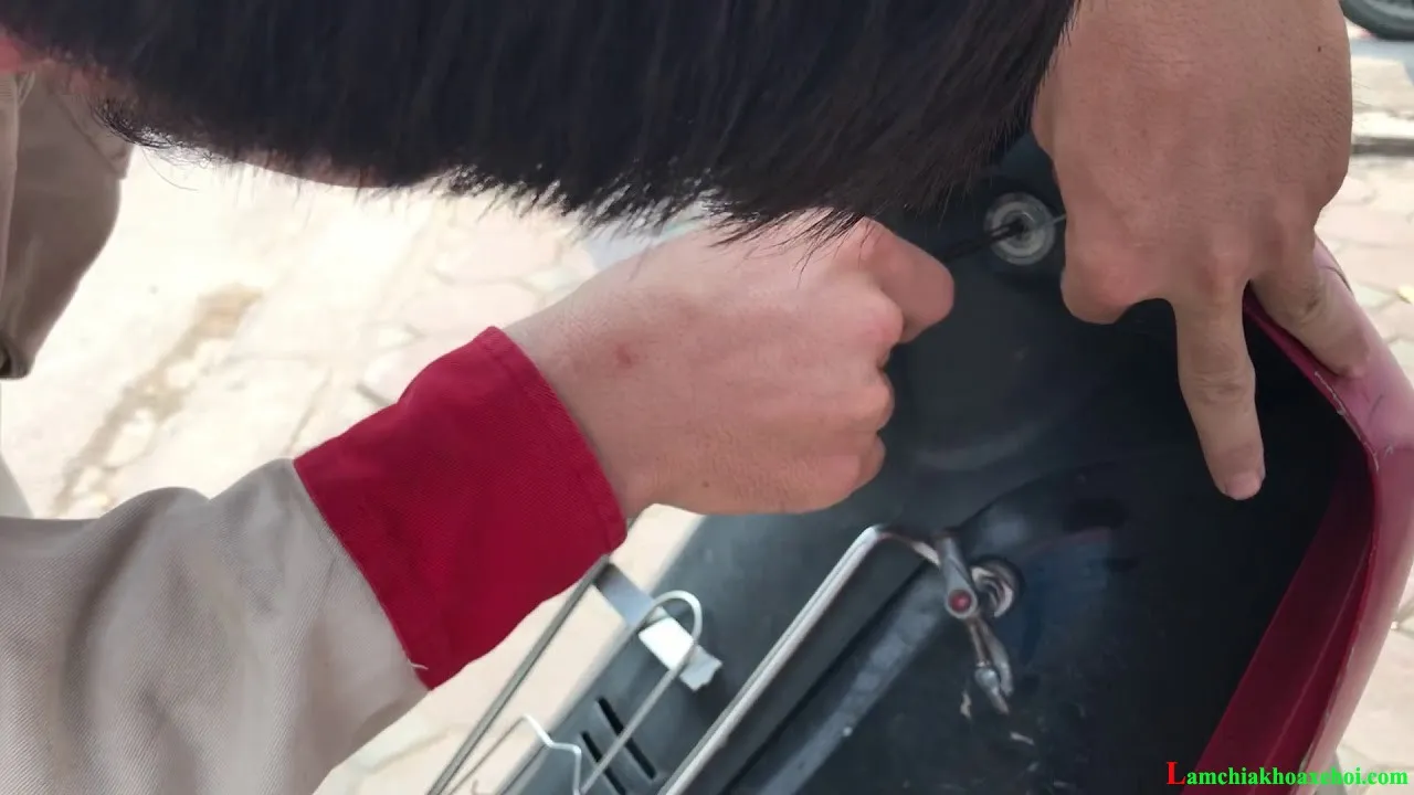 Hình ảnh minh họa cách sửa ổ khóa xe máy khi có dị vật bị kẹt bên trong, sử dụng nhíp chuyên dụng để gắp bỏ vật cản, đảm bảo chức năng mở khóa trơn tru