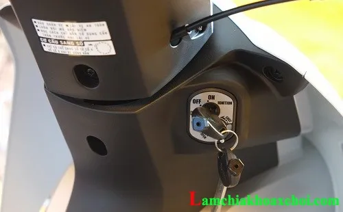 Ảnh chụp chi tiết một người đang tự sửa ổ khóa xe máy tại nhà bằng cách tra dầu chống rỉ sét, khắc phục tình trạng kẹt cứng hoặc khó vặn chìa khóa