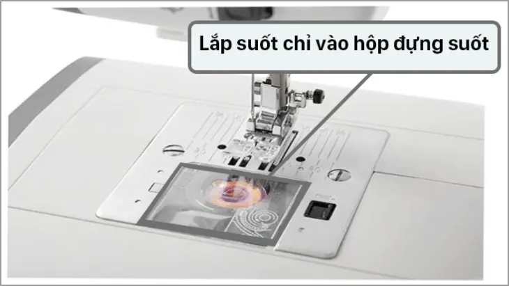 Thao tác lắp hộp suốt chỉ đã gắn suốt vào lại ổ máy may mini một cách chính xác