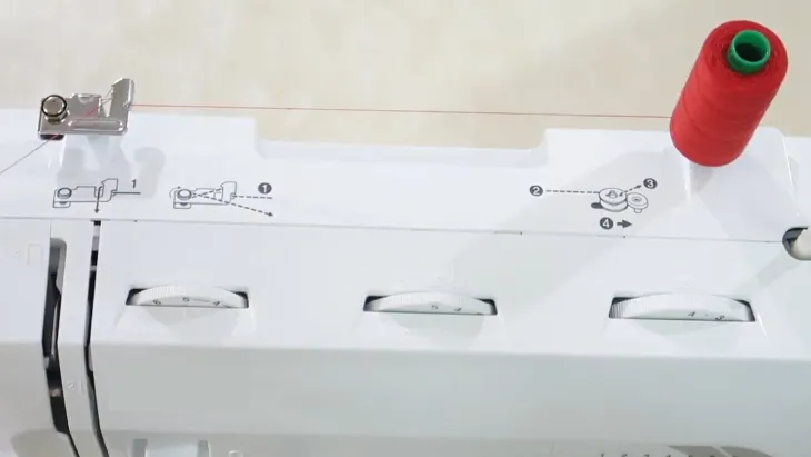 Gắn cuộn chỉ chính vào trục giữ chỉ phía trên của máy may mini