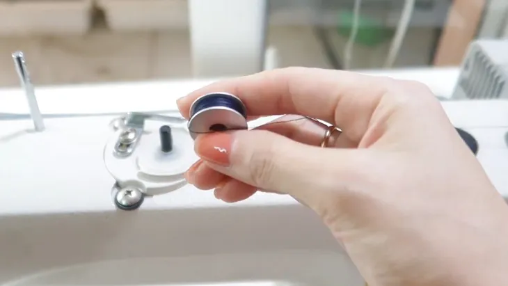 Hoàn tất quá trình và lấy suốt chỉ đã đầy ra khỏi máy may mini