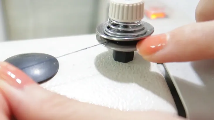 Luồn sợi chỉ qua hệ thống căng chỉ kép trên máy may mini