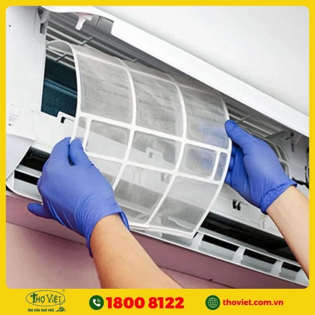 Kỹ thuật viên đang tháo dàn lạnh máy điều hòa để vệ sinh, tập trung vào kết nối ống đồng