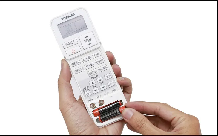 Tháo hai viên pin cũ ra khỏi remote máy lạnh Toshiba