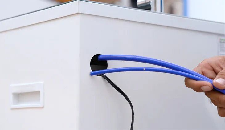 Luồn ống cấp và thoát nước qua lỗ phía sau thân máy lọc, đảm bảo đường ống gọn gàng và không bị gấp khúc.