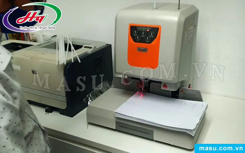 Đặt chồng giấy thẳng gọn vào bệ khoan, một bước quan trọng trong cách sử dụng máy đóng chứng từ