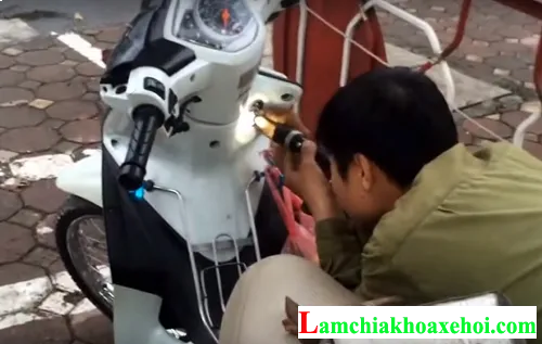 Kỹ thuật viên đang khắc phục ổ khóa xe máy bị hỏng, minh họa sự cần thiết của chuyên môn trong việc tìm hiểu cách mở ổ khóa xe máy khi gặp sự cố