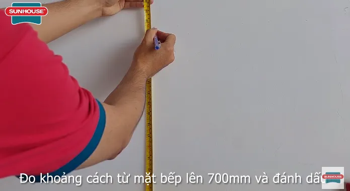 Đo và đánh dấu khoảng cách lắp đặt máy hút mùi kính cong so với mặt bếp