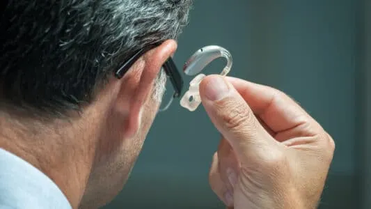 Người lớn tuổi đang làm quen với cách sử dụng máy trợ thính trong giai đoạn thích nghi ban đầu