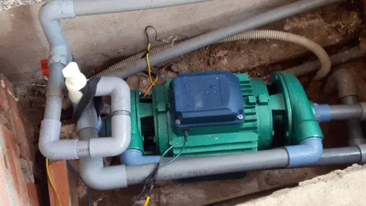 Kỹ thuật viên đang kiểm tra các mối nối và đường ống sau khi hoàn tất việc lắp đặt máy bơm giếng khoan, nhấn mạnh tầm quan trọng của việc kiểm tra kỹ lưỡng để đảm bảo an toàn và hiệu suất hệ thống.