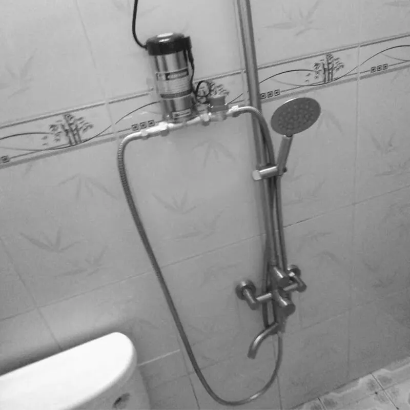 Hình ảnh minh họa việc lắp đặt máy bơm tăng áp mini cho vòi sen, giúp nước chảy mạnh và ổn định hơn.